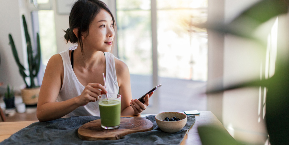 woman drinking green smoothie